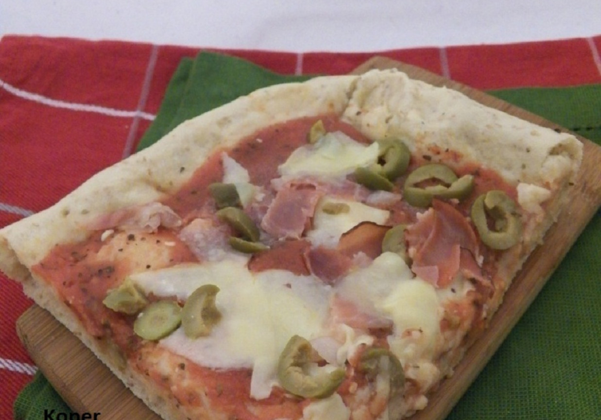 Pełnoziarnista pizza z serem, szynką i oliwkami foto