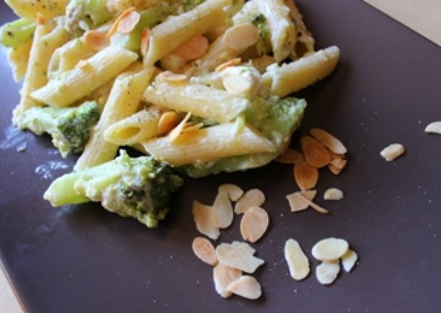 Fotografia przedstawiająca Penne z brokułami w sosie jogurtowo - serowym i prażonymi migdałami z fetą