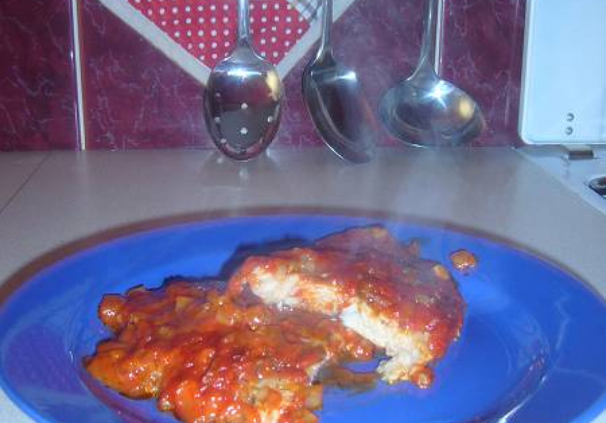 Pieczona ryba w sosie pomidorowym z czosnkiem, cebulą i koperkiem. foto