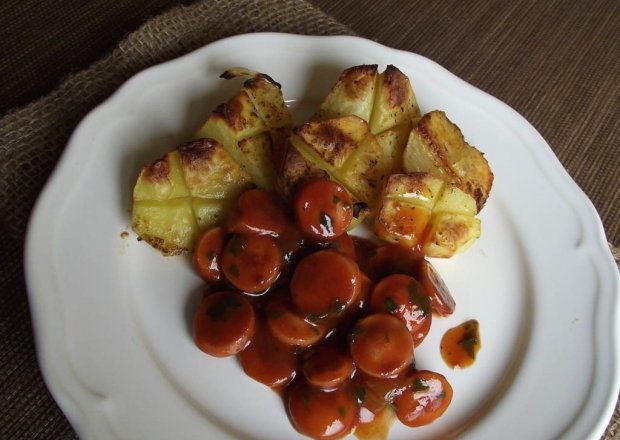 Fotografia przedstawiająca Pieczone ziemniaki podane z parówkami w pomidorowym sosie z natką pietruszki