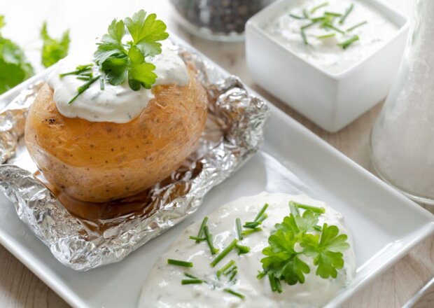 Fotografia przedstawiająca Pieczone ziemniaki z sosem z czosnkiem i serem pleśniowym