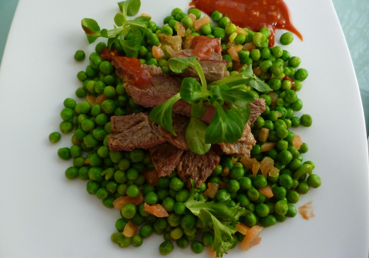 Pieczony antrykot z wołowiny z sosem barbecue, zielonym groszkiem i pomidorami foto