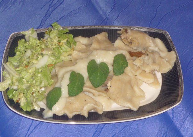 Fotografia przedstawiająca Pierogi z mięsem i smażonymi maślakami w sosie kalafiorowym