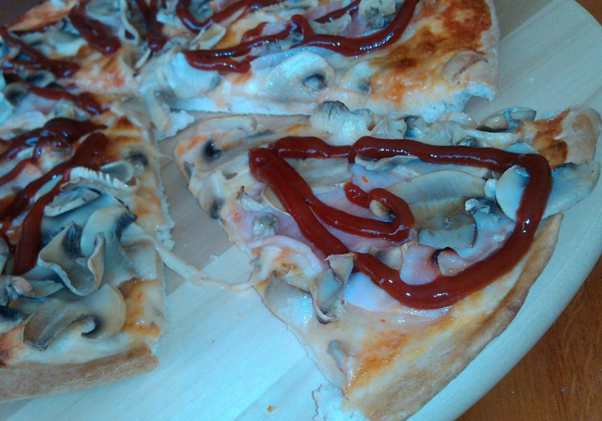 Pikantna okrągła pizza z szynką pieczarkami i mozzarellą  foto