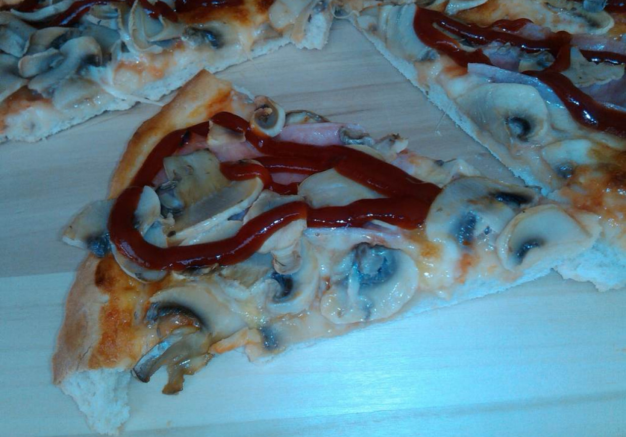 Pikantna okrągła pizza z szynką pieczarkami i mozzarellą  foto