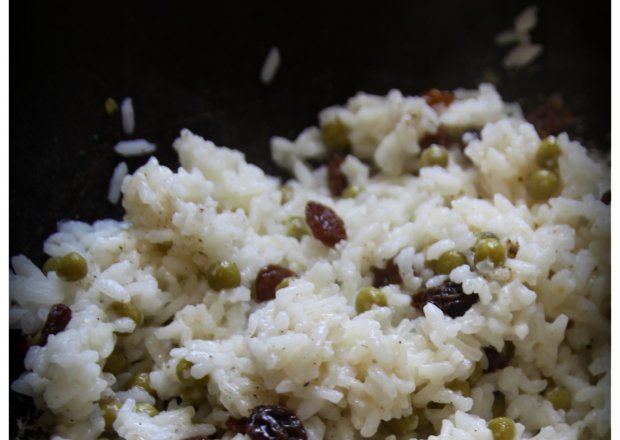 Fotografia przedstawiająca pikantny ryż do obiadu z rodzynkami i groszkiem