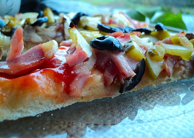 Fotografia przedstawiająca Pizza na cienkim cieście z pikantnym ogórkiem, szynką parmeńską