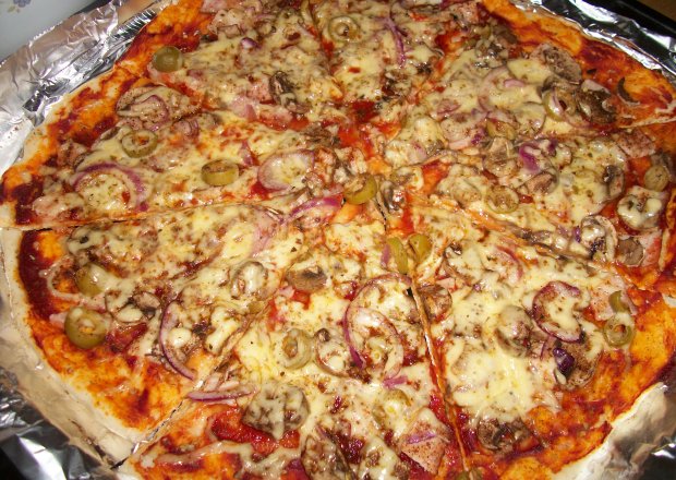 Fotografia przedstawiająca Pizza na cienkim cieście z szynką i pieczarkami