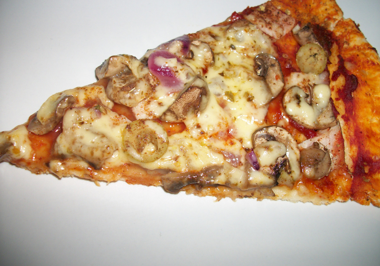 Pizza na cienkim cieście z szynką i pieczarkami foto