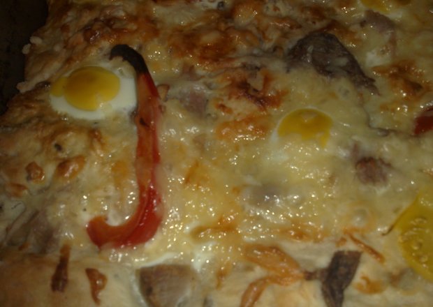 Fotografia przedstawiająca pizza na grubym spodzie z jajami przepiórczymi