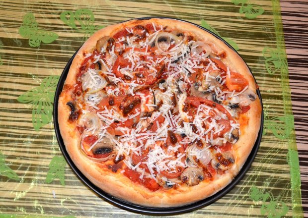 Fotografia przedstawiająca Pizza na pełnoziarnistym cieście z pieczarkami, cebulą, pomidorami i serem grana padano
