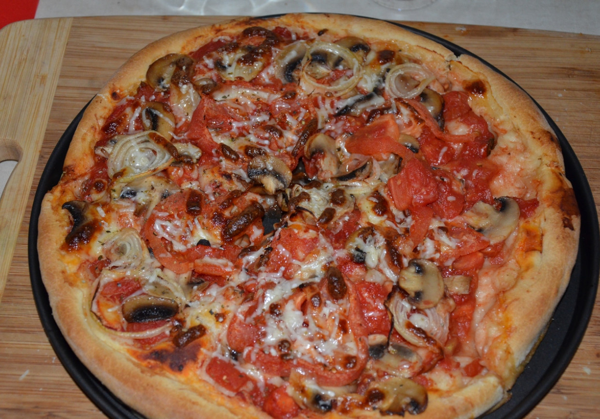 Pizza na pełnoziarnistym cieście z pieczarkami, cebulą, pomidorami i serem grana padano foto