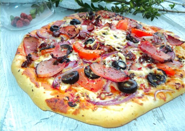 Fotografia przedstawiająca Pizza na ziołowym cieście z trzema serami i dodatkami