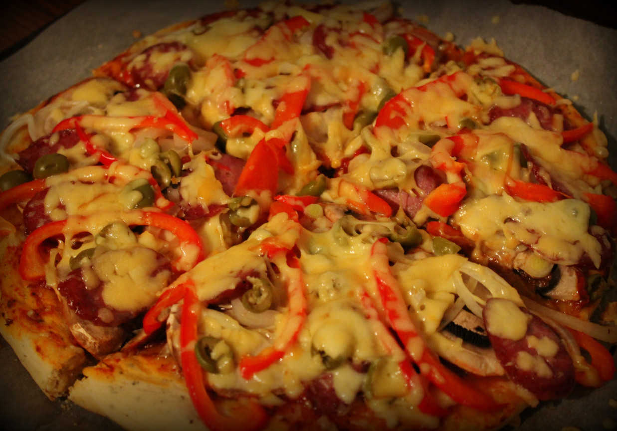 Pizza puszysta z kiełbasą, papryką i oliwkami foto