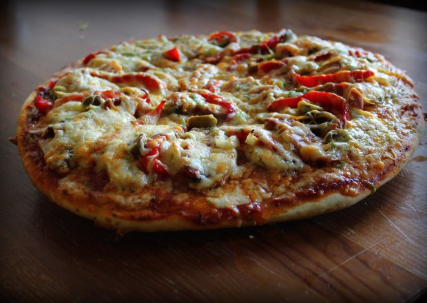 Fotografia przedstawiająca Pizza serowa z polędwicą, papryką i oliwkami