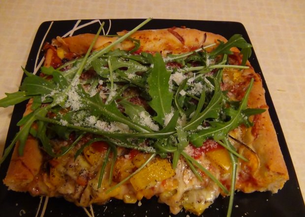 Fotografia przedstawiająca Pizza wegetariańska z rukolą i parmezanem
