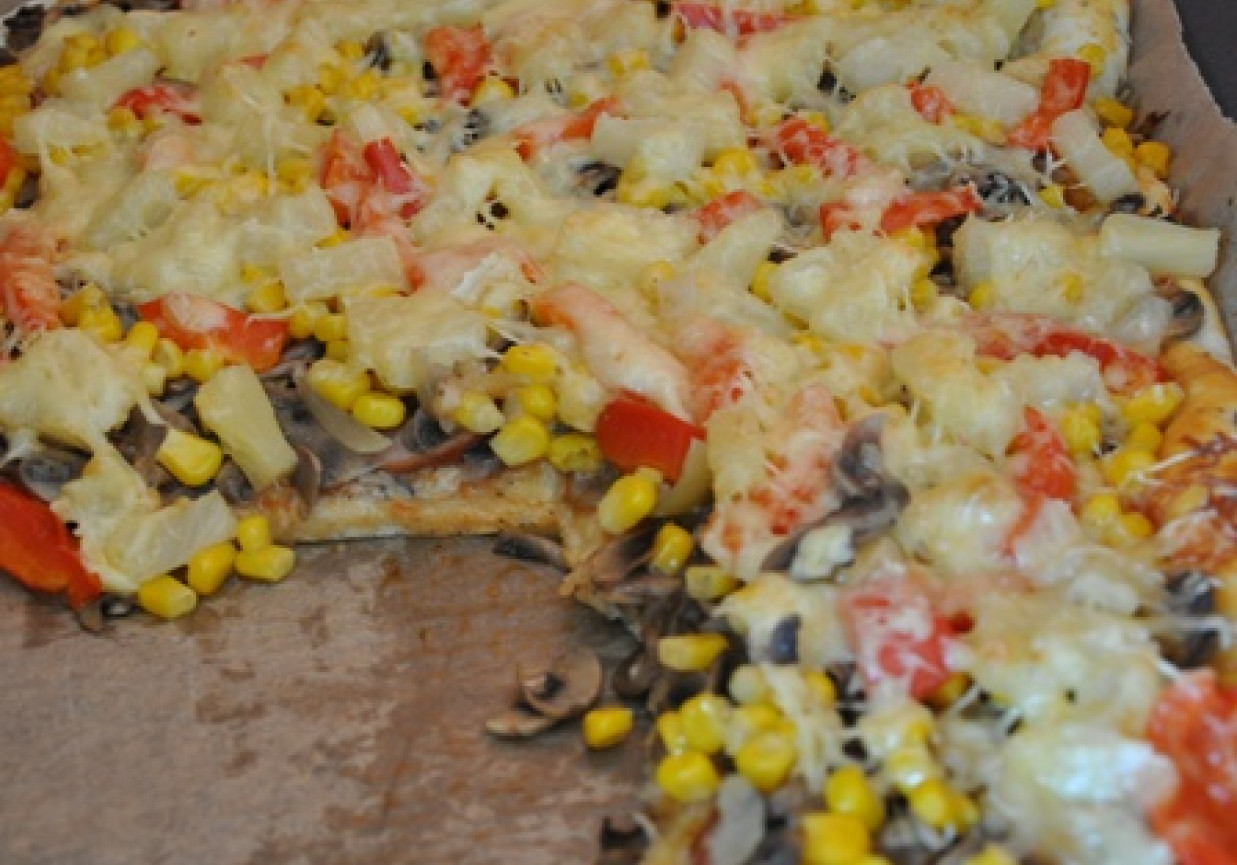 pizza z ananasem, kukurydzą, pieczarkami, cebulą, papryką, wędliną i serem. foto
