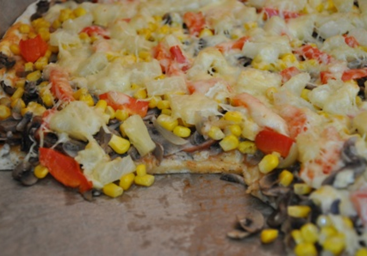 pizza z ananasem, kukurydzą, pieczarkami, cebulą, papryką, wędliną i serem. foto