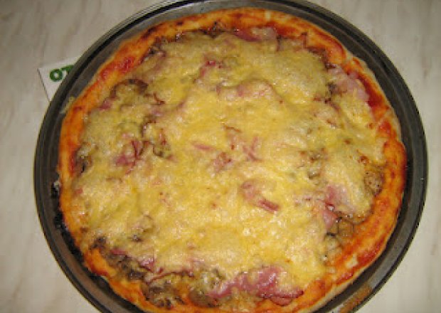 Fotografia przedstawiająca Pizza z bekonem, szynką i pieczarkami