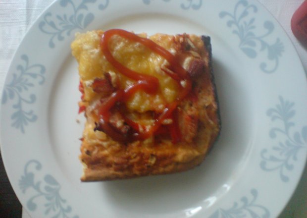 Fotografia przedstawiająca Pizza z boczkiem, cebulą, czerwoną papryką i serem