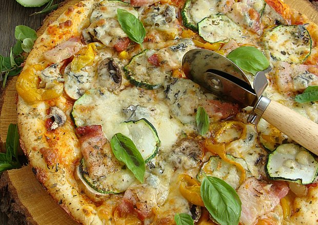Fotografia przedstawiająca Pizza z boczkiem papryką cukinią pieczarkami i serem pleśniowym