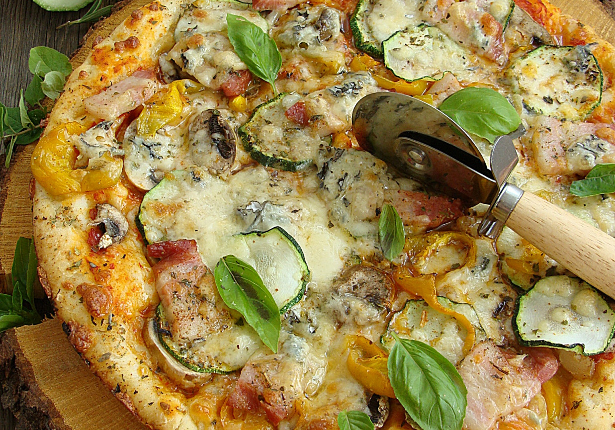 Pizza z boczkiem papryką cukinią pieczarkami i serem pleśniowym foto