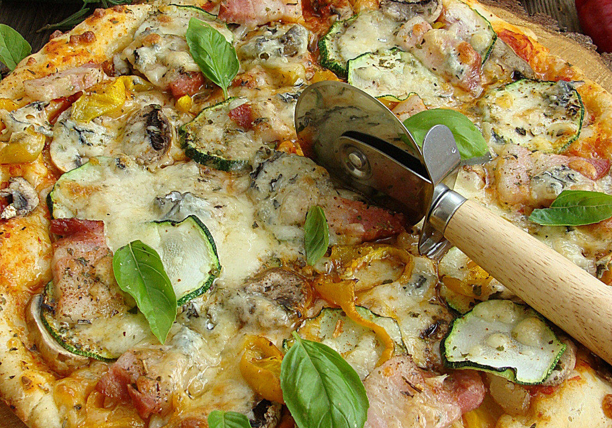Pizza z boczkiem papryką cukinią pieczarkami i serem pleśniowym foto