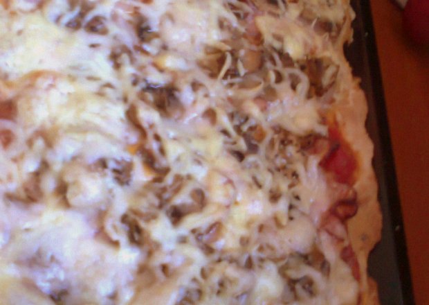 Fotografia przedstawiająca pizza z boczkiem, pieczarkami i serem, spód z dodatkiem oregano