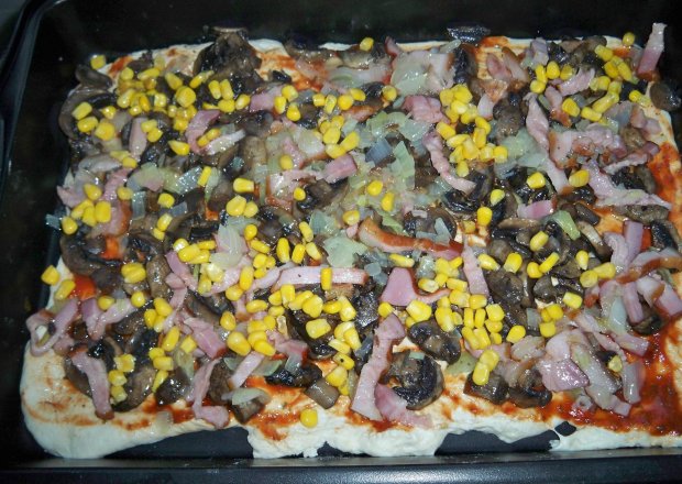 Fotografia przedstawiająca Pizza z cebulką, boczkiem, kukurydzą i pierczarkami