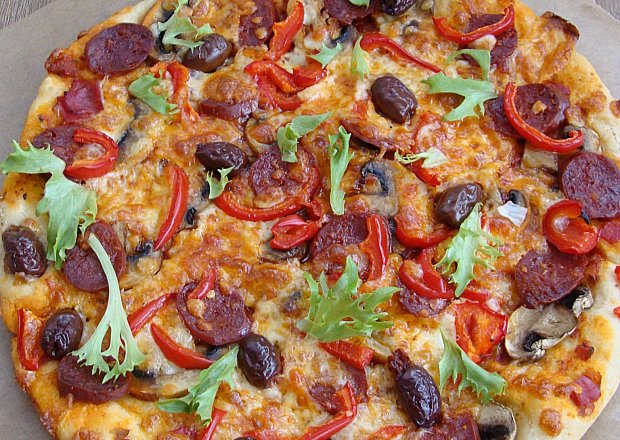 Fotografia przedstawiająca Pizza z chorizo oliwkami kalamata i mozzarellą