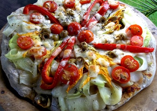 Fotografia przedstawiająca pizza z cukinią i kwiatami cukinii