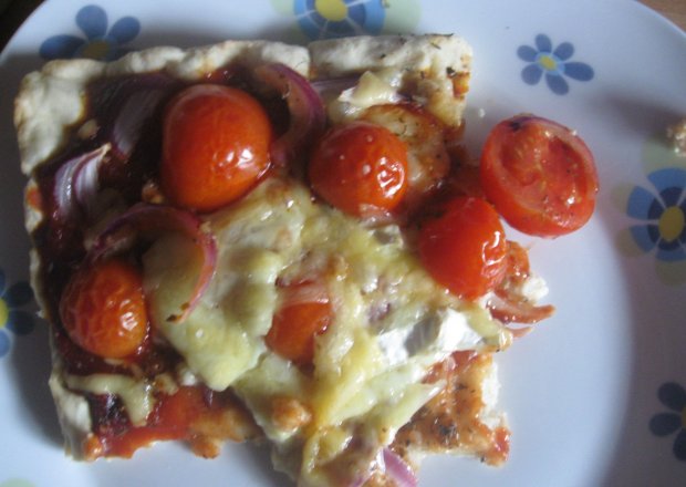 Fotografia przedstawiająca Pizza z kabanosami i pomidorkami koktajlowymi