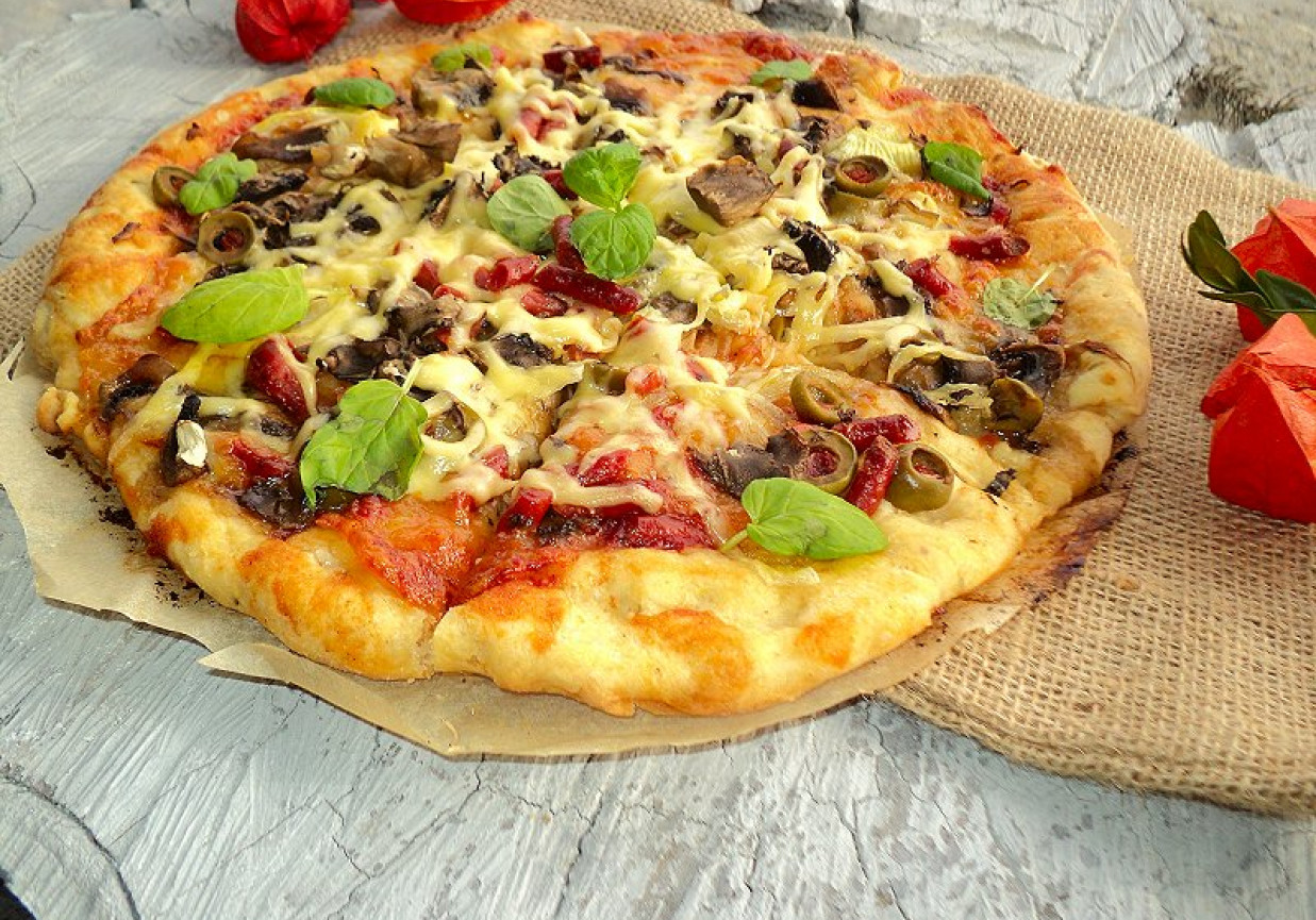 Pizza z kabanosem długo dojrzewajacym mozarellą  pieczarkami  cebulą foto