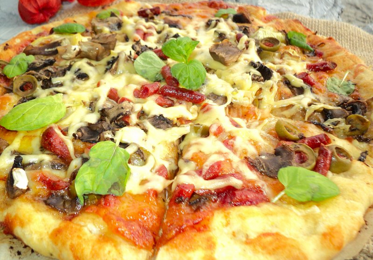 Pizza z kabanosem długo dojrzewajacym mozarellą  pieczarkami  cebulą foto