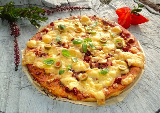 Fotografia przedstawiająca Pizza z kabanosem ,oliwkami cebulą