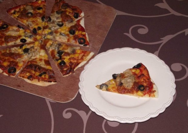 Fotografia przedstawiająca Pizza z kamienia na cienkim cieście z makrelą, kukurydzą i oliwkami