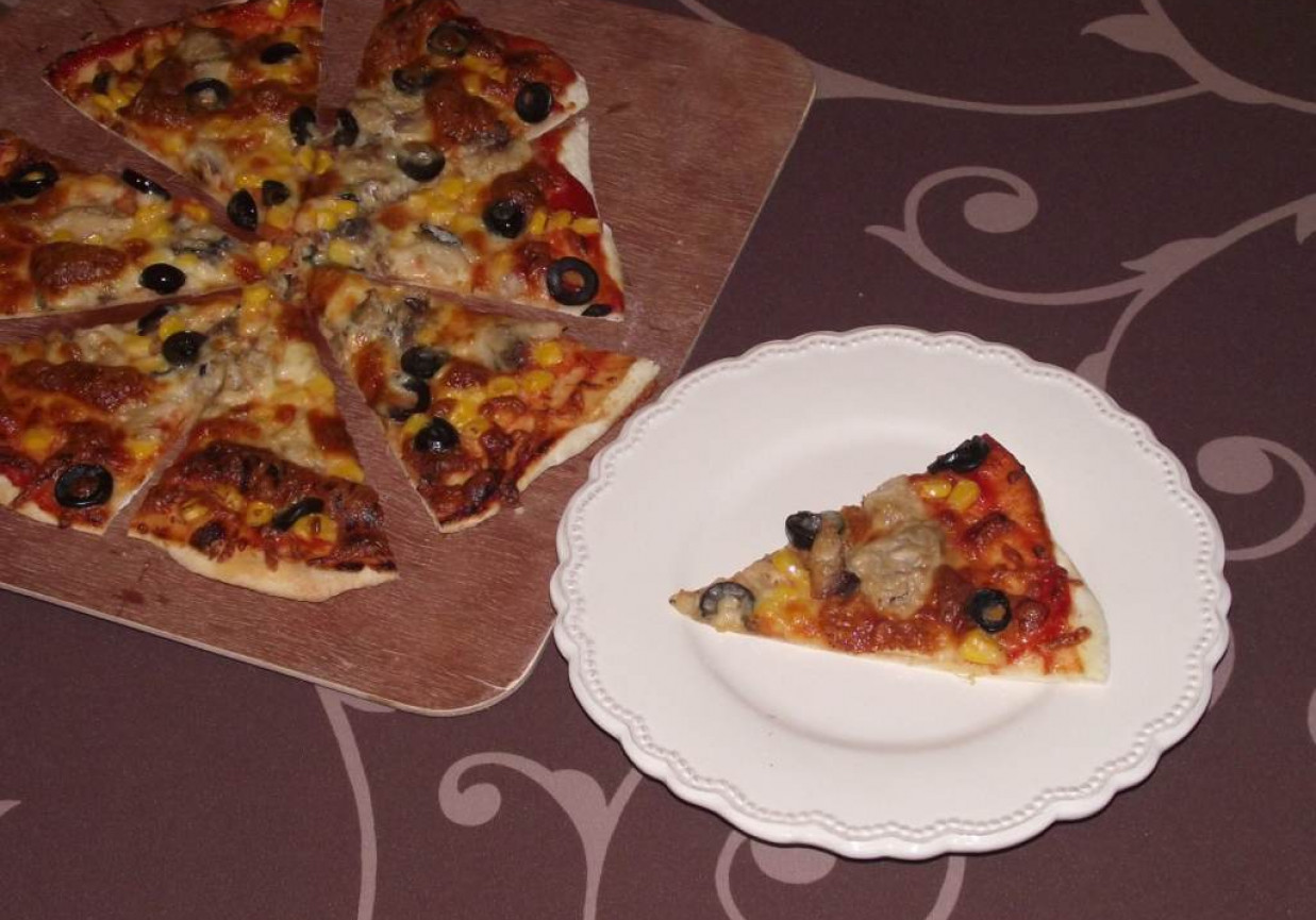 Pizza z kamienia na cienkim cieście z makrelą, kukurydzą i oliwkami  foto
