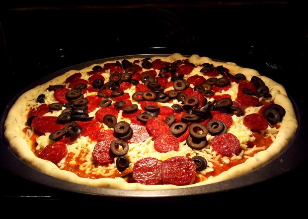 Fotografia przedstawiająca Pizza z kiełbasą chorizo, oliwkami i szpinakiem