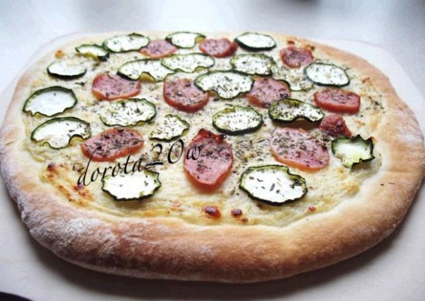 Fotografia przedstawiająca Pizza z kiełbasą i cukinią pieczona na kamieniu