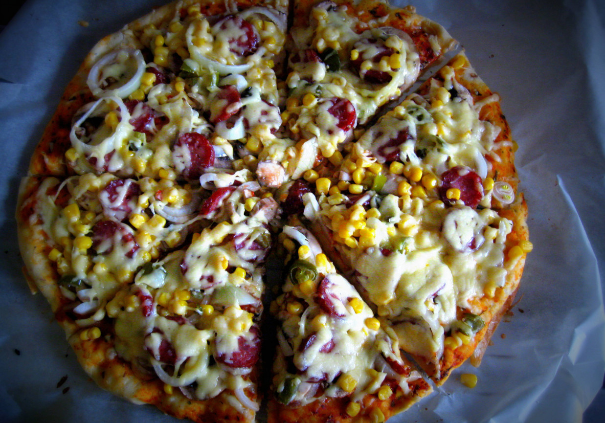 Pizza z kiełbasą, kukurydzą, cebulą i ostrą papryczką foto