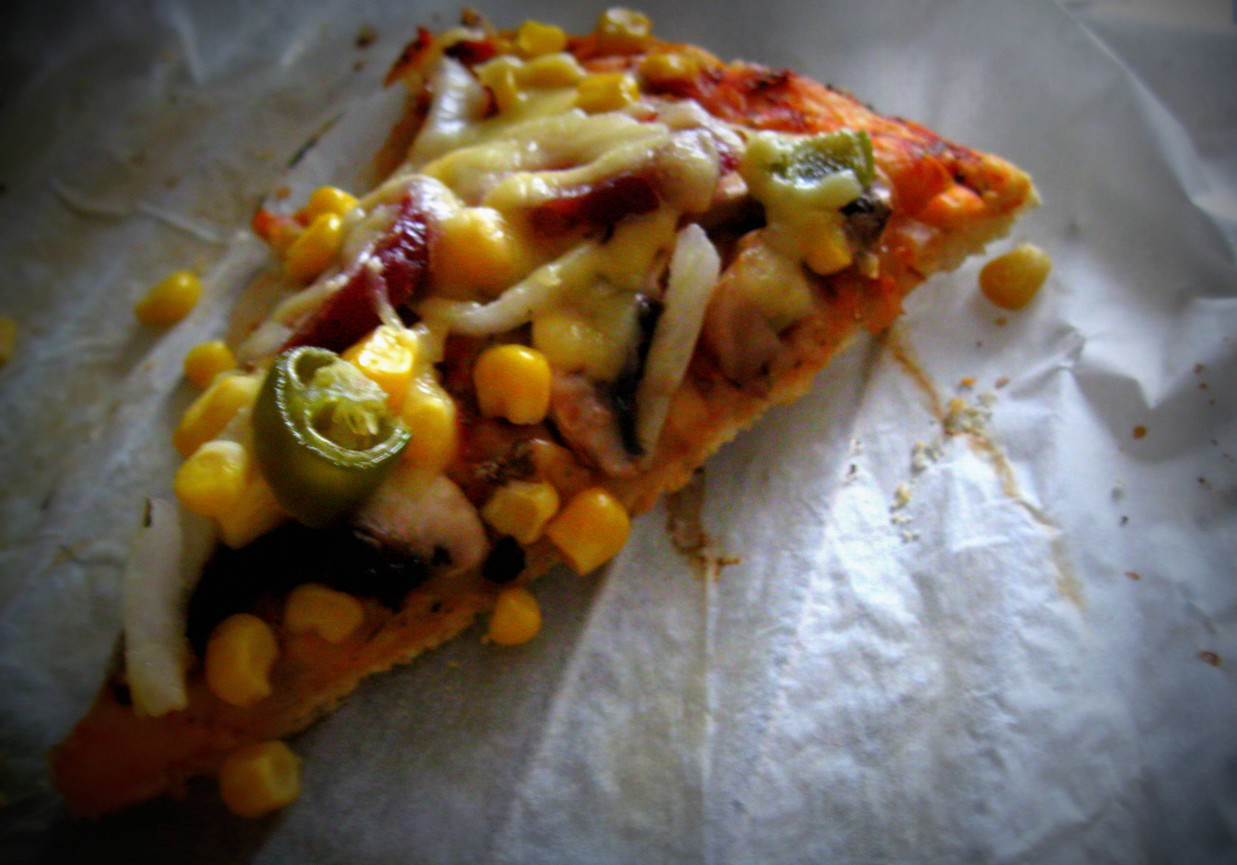 Pizza z kiełbasą, kukurydzą, cebulą i ostrą papryczką foto
