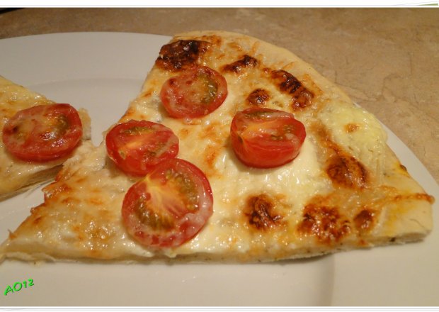 Fotografia przedstawiająca pizza z mascarpone i pomidorkami koktajlowymi