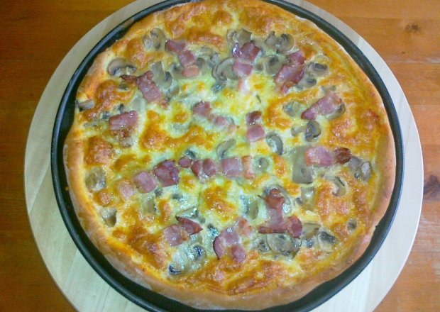 Fotografia przedstawiająca Pizza z mozzarellą i boczkiem z odrobiną pikanteri