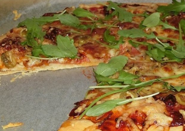 Fotografia przedstawiająca Pizza z mozzarellą, suszonymi pomidorami i rukolą