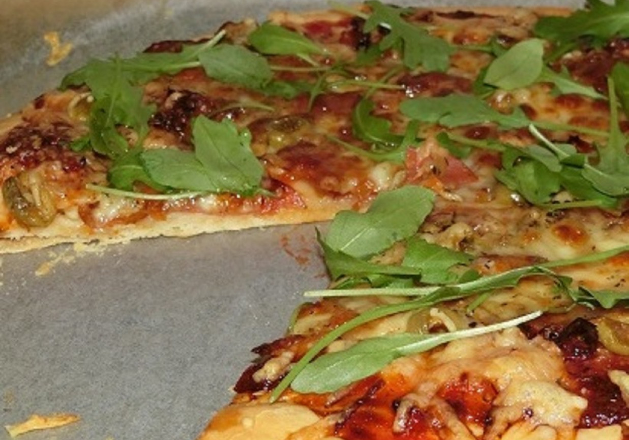 Pizza z mozzarellą, suszonymi pomidorami i rukolą foto