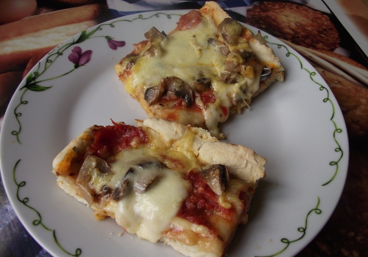 Pizza z mozzarellą, szynką i pieczarkami. foto