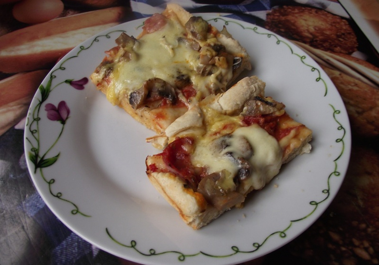 Pizza z mozzarellą, szynką i pieczarkami. foto