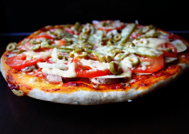 Fotografia przedstawiająca Pizza z ogórkiem konserwowym, pomidorem i oliwkami