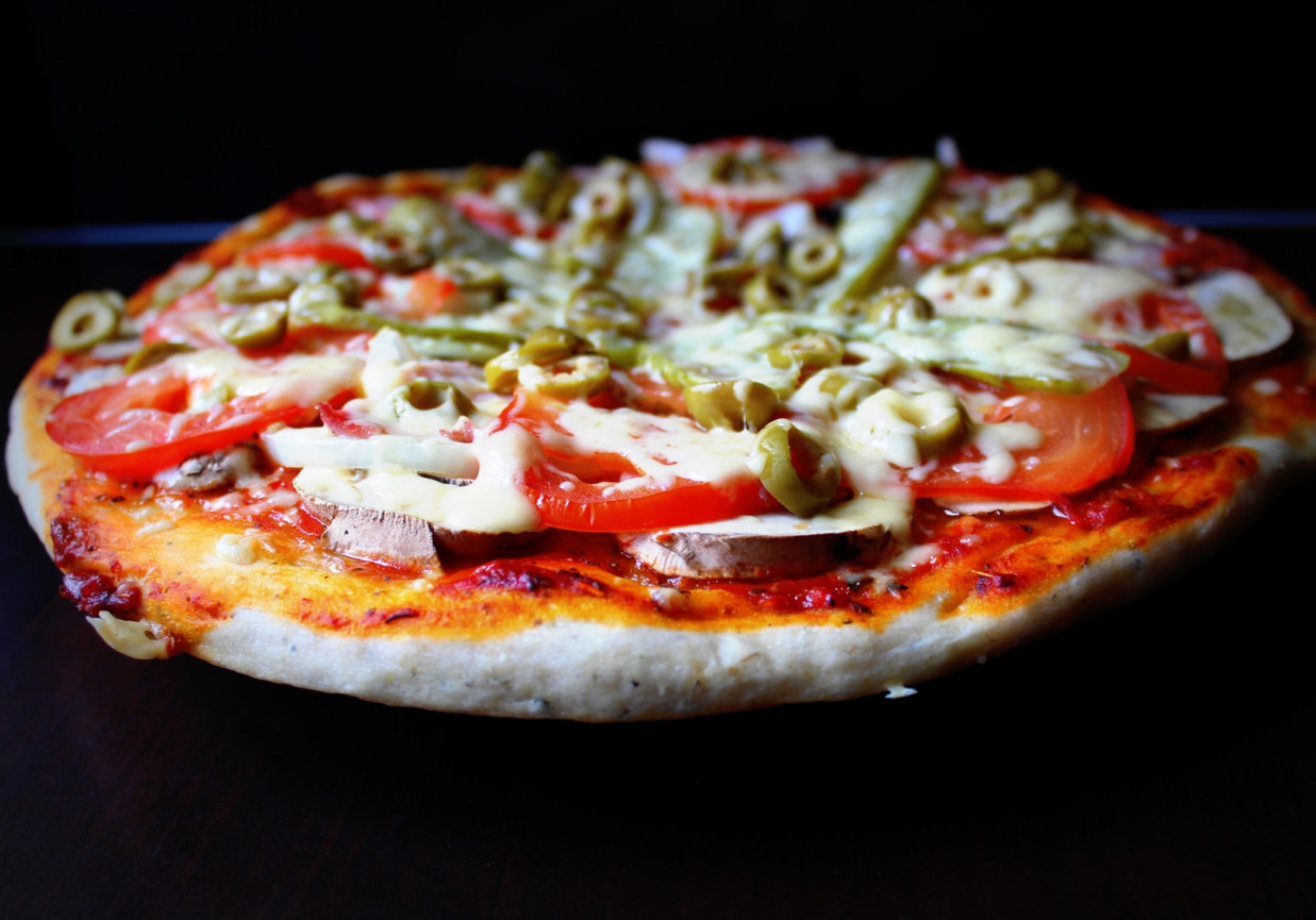 Pizza z ogórkiem konserwowym, pomidorem i oliwkami foto