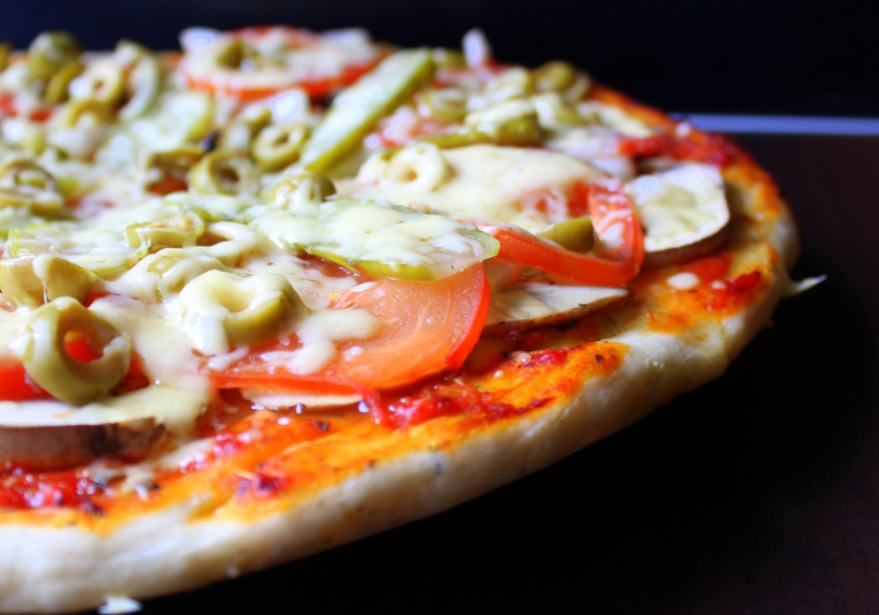 Pizza z ogórkiem konserwowym, pomidorem i oliwkami foto